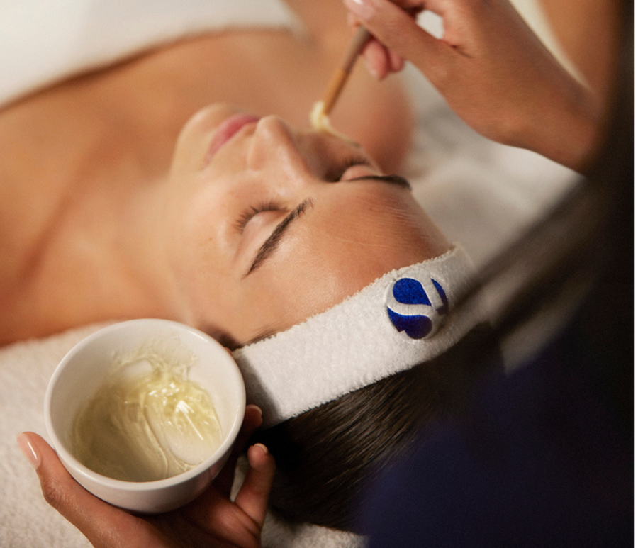 Therapist applying an iS Clinical treatment mask during a facial