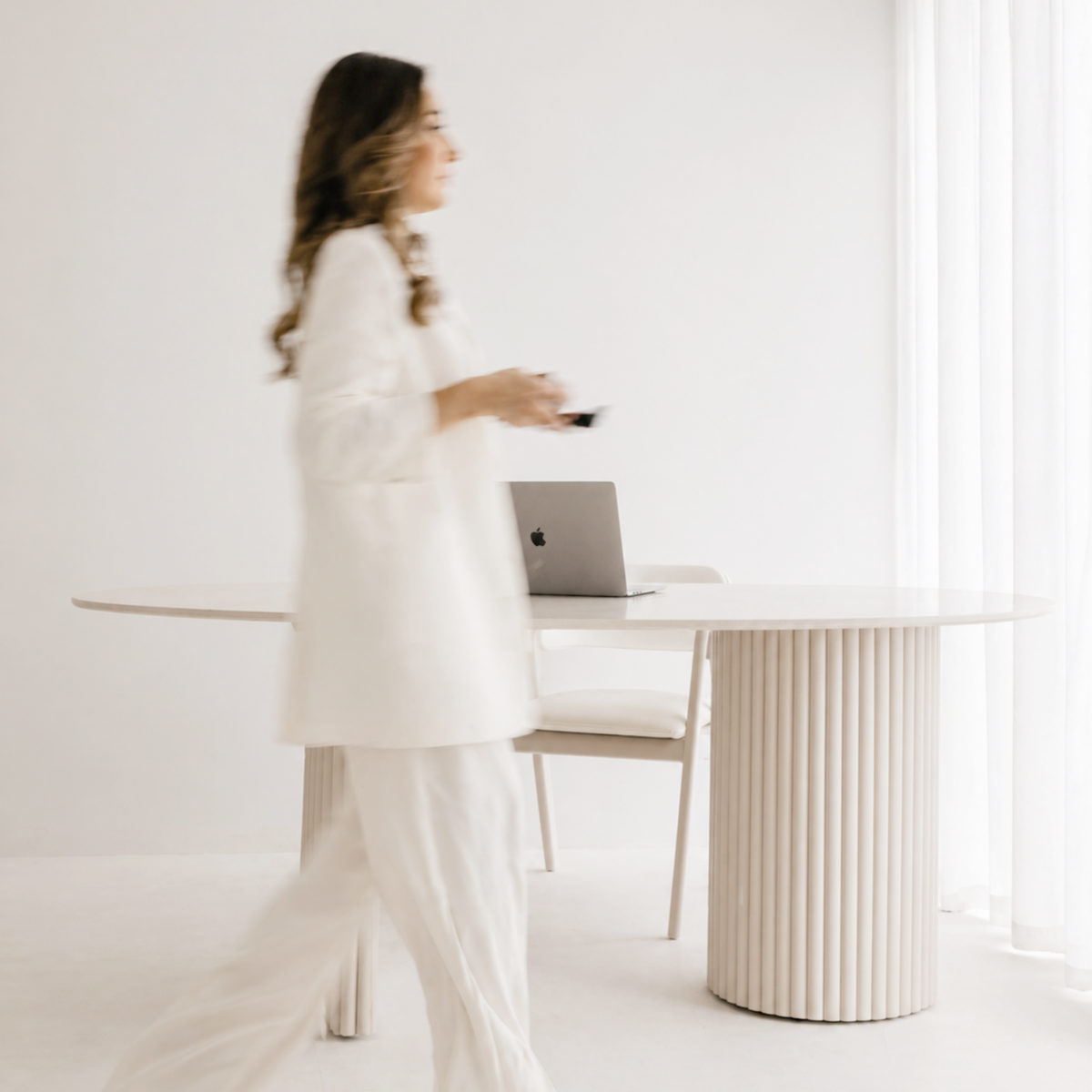 Professional walking through a bright, minimal HGI workspace