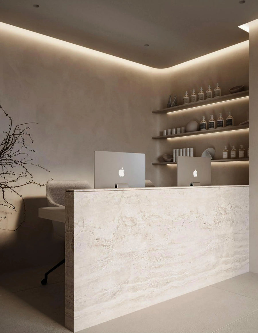 Minimal reception desk with a laptop and product shelving
